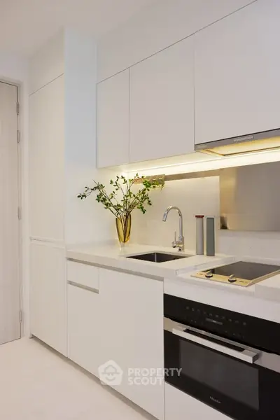 Modern kitchen with sleek white cabinetry and built-in appliances