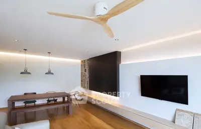 Modern living room with wooden flooring, ceiling fan, and wall-mounted TV for a cozy ambiance.