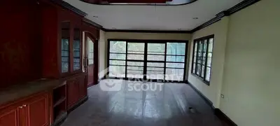 Spacious living room with large windows and wooden cabinetry, perfect for natural light lovers.