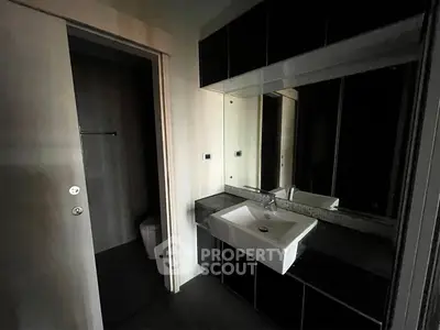 Modern bathroom with sleek black cabinetry and a stylish white sink.