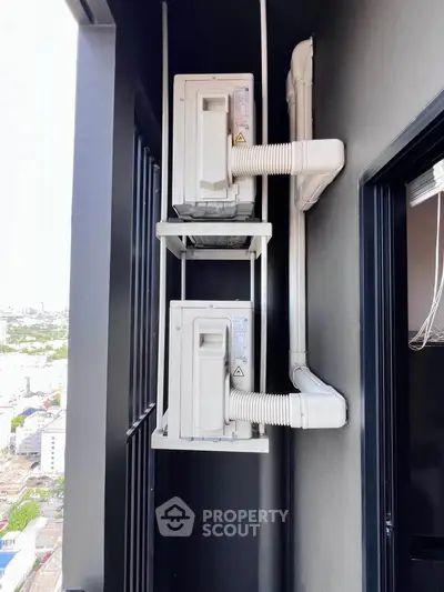 Modern apartment balcony with dual air conditioning units and city view.
