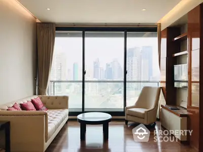 Elegant living room with large windows offering a panoramic city view, modern furniture, and warm wooden flooring.