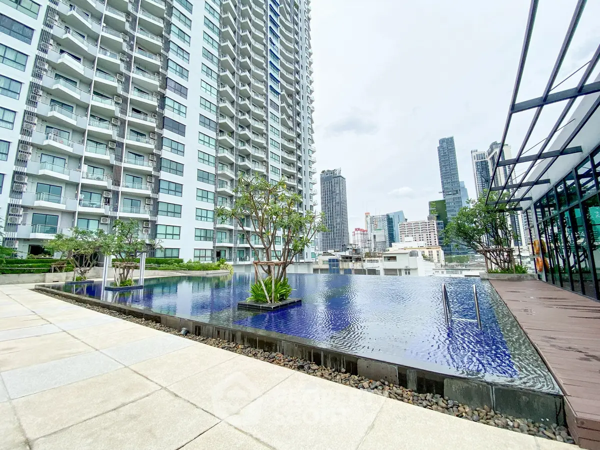 Luxurious high-rise apartment with stunning infinity pool and city skyline view, perfect for urban living.