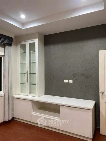 Modern living room with built-in white cabinetry and elegant recessed lighting.