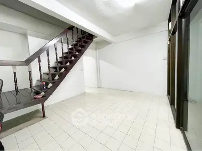 Spacious interior with tiled flooring and wooden staircase, ideal for modern living.