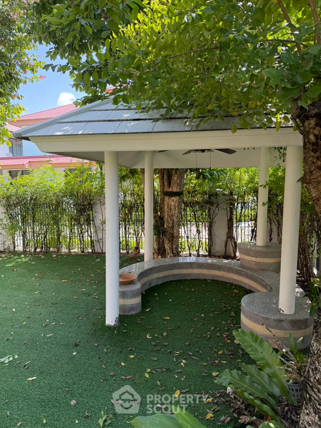 Charming garden gazebo with lush greenery and cozy seating, perfect for relaxation and outdoor gatherings.