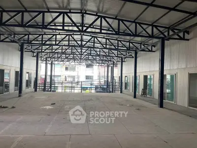 Spacious industrial-style open space with high ceilings and large windows