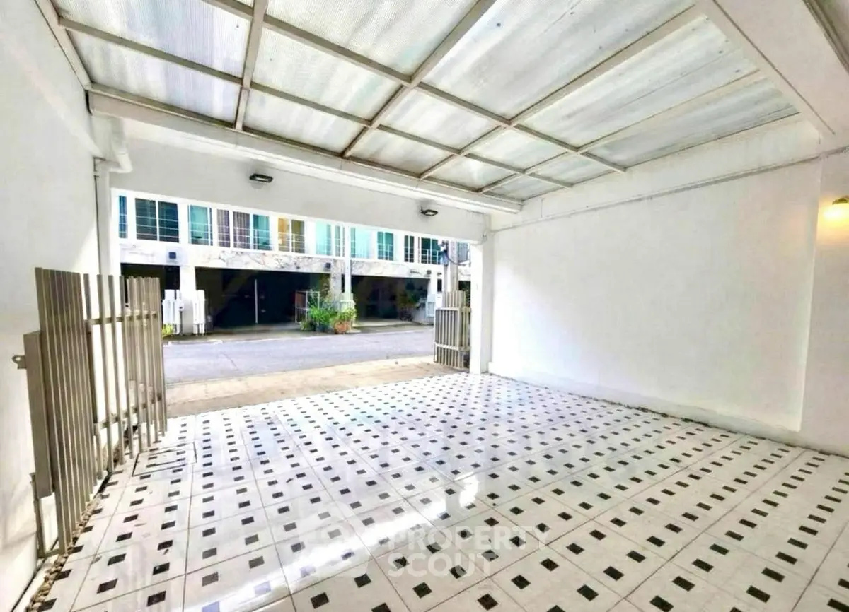 Spacious covered parking area with tiled flooring and gated entrance in modern building.