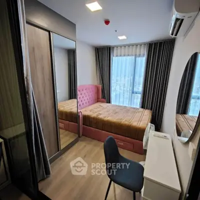 Modern bedroom with pink bed, mirrored wardrobe, and city view window.