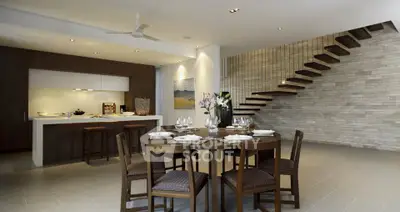 Modern open-plan kitchen and dining area with stylish staircase and elegant decor.