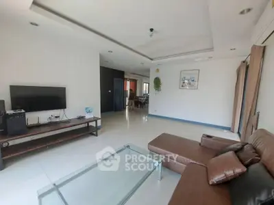 Spacious modern living room with sleek furniture and natural light, perfect for relaxation and entertainment.