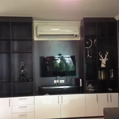 Modern living room with built-in shelving and air conditioning unit