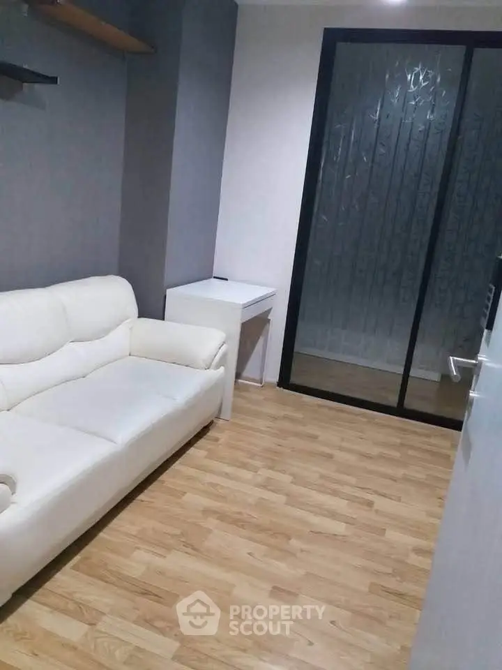 Cozy small living room with white sofa and wooden flooring
