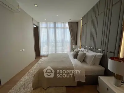 Luxurious bedroom with modern decor and large windows offering stunning city views.