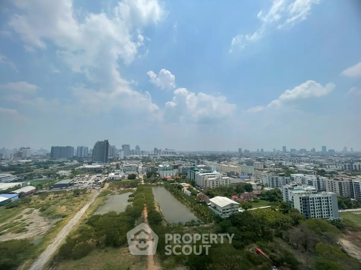 Stunning panoramic cityscape view from high-rise building, showcasing urban skyline and lush greenery.