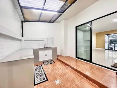 Modern kitchen with sleek design and open layout, featuring tiled flooring and ample natural light.