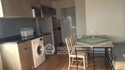 Modern kitchen with washing machine and dining area in open layout apartment.