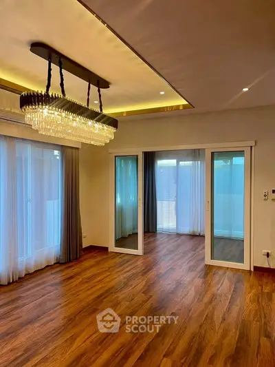 Luxurious living room with elegant chandelier and wooden flooring