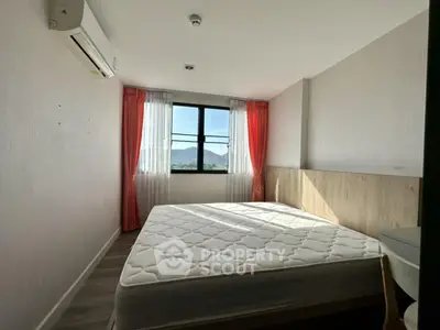 Cozy bedroom with mountain view, featuring a large window and modern decor.