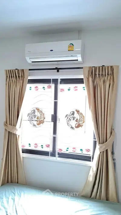 Cozy bedroom with air conditioning and elegant curtains, perfect for comfort and relaxation.