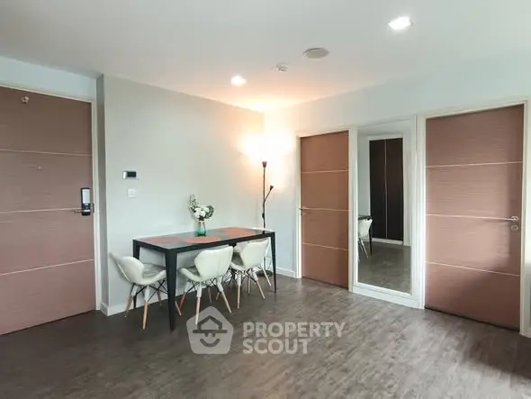 Modern dining area with stylish table and chairs, wooden flooring, and elegant lighting.