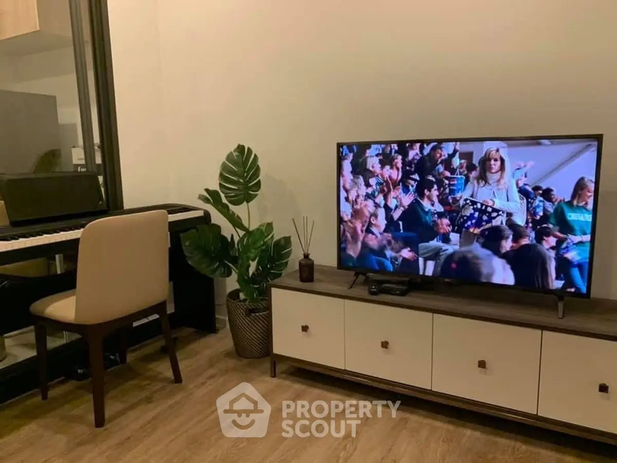 Stylish living room with modern TV setup and elegant piano corner.