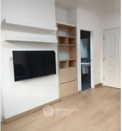 Modern living room with wall-mounted TV and built-in shelving unit