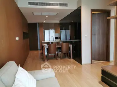 Modern open-plan living room and kitchen with sleek design and wooden flooring.