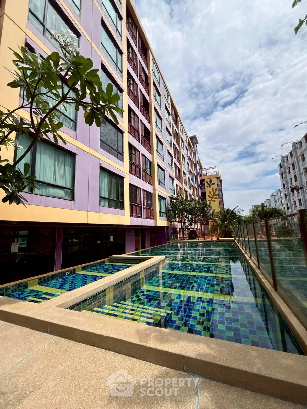Modern apartment building with colorful facade and stylish outdoor pool area.