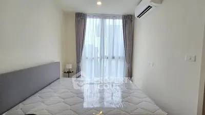 Modern bedroom with large window and air conditioning in a stylish apartment.