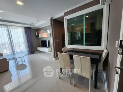 Modern open-plan living room with dining area and large windows offering city views.