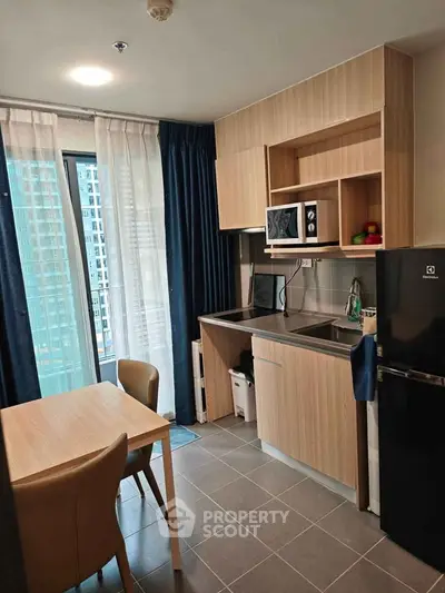 Modern kitchen with sleek cabinetry and dining area in a stylish apartment