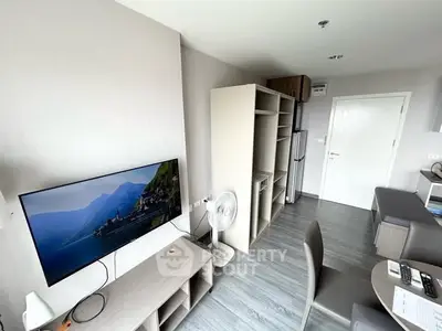 Modern living room with wall-mounted TV and sleek furniture in a stylish apartment.