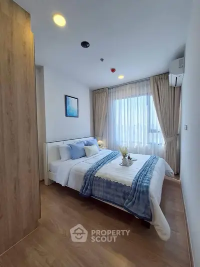 Cozy bedroom with modern decor and large window for natural light