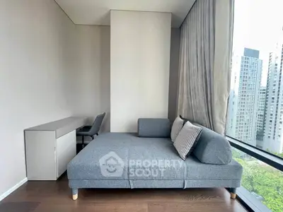 Modern living room with stylish gray sofa and city view through large windows.