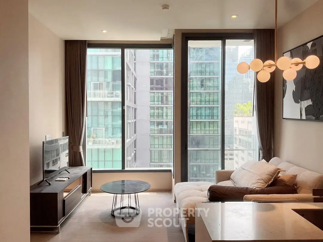 Modern living room with large windows and city view, stylish lighting and cozy furniture.