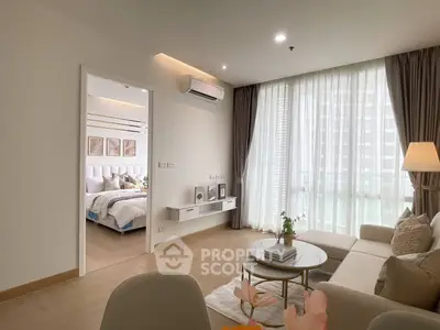 Modern living room with elegant decor and natural light, adjacent to a cozy bedroom.