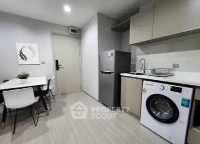 Modern kitchen with dining area, featuring sleek appliances and stylish decor.