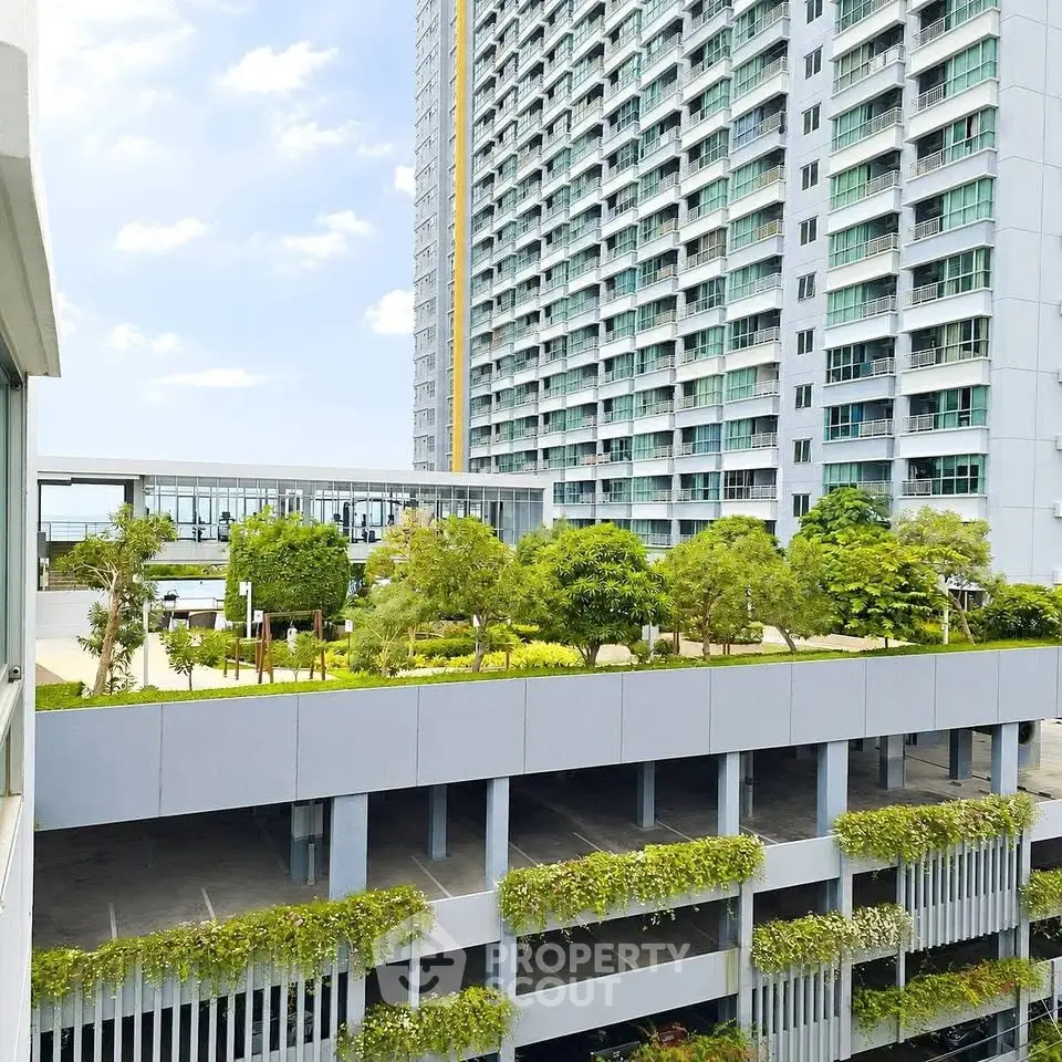 Modern high-rise building with lush rooftop garden and parking area