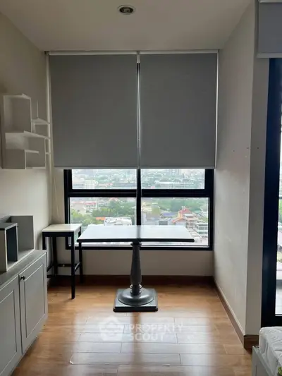 Modern study room with large window offering stunning city view, featuring sleek furniture and wooden flooring.