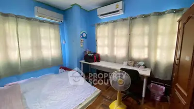 Cozy bedroom with blue walls, air conditioning, and a study desk, perfect for comfort and productivity.