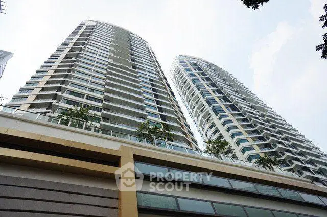 Stunning modern high-rise residential building with sleek architecture and lush greenery.