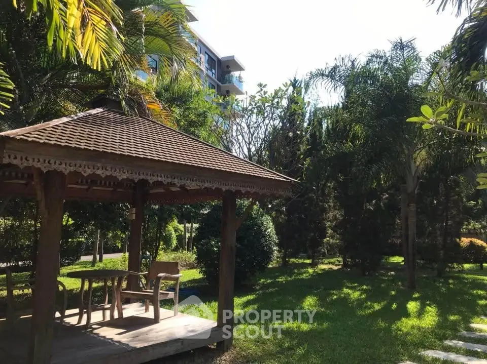 Charming garden with wooden gazebo and lush greenery in serene residential area.
