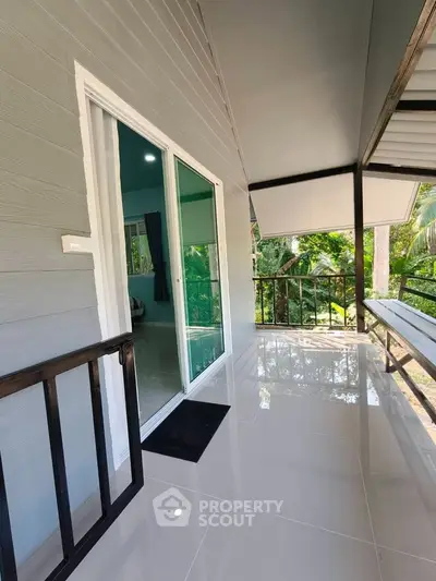 Charming balcony with glossy tiles and lush green view, perfect for relaxation and enjoying nature.