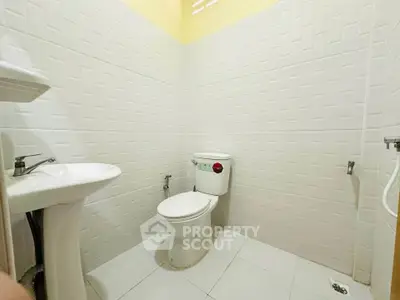 Modern bathroom with white tiles and sleek fixtures in a contemporary home.