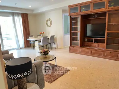 Spacious living room with elegant decor and natural light, featuring a dining area and entertainment center.