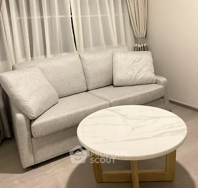 Modern living room with elegant gray sofa and stylish marble coffee table.