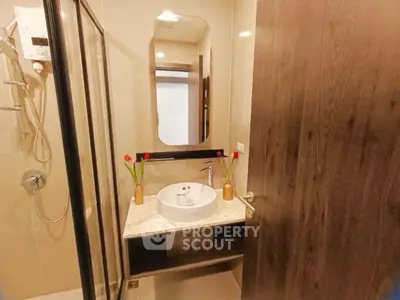 Modern bathroom with elegant sink and shower in stylish real estate property.