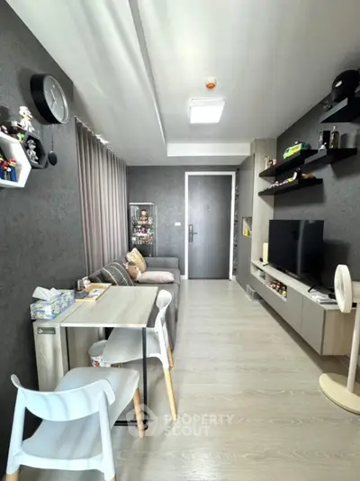 Modern living room with sleek furniture and wall-mounted TV, featuring stylish decor and ample natural light.