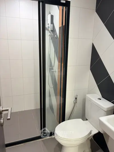 Modern bathroom with sleek shower enclosure and stylish tile design.